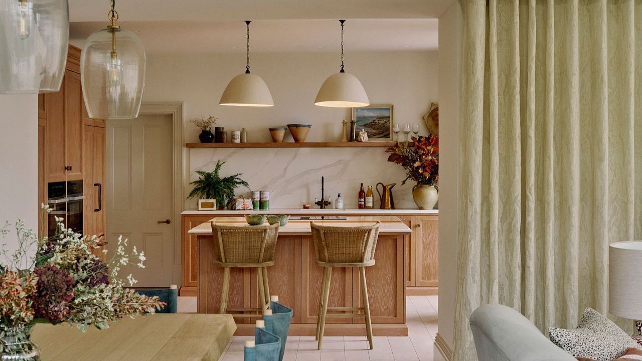 An open-plan kitchen-diner with wooden cabinets, white walls, and a countersplash