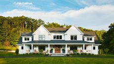 large white Connecticut home with a large porch, porch furniture and front lawn