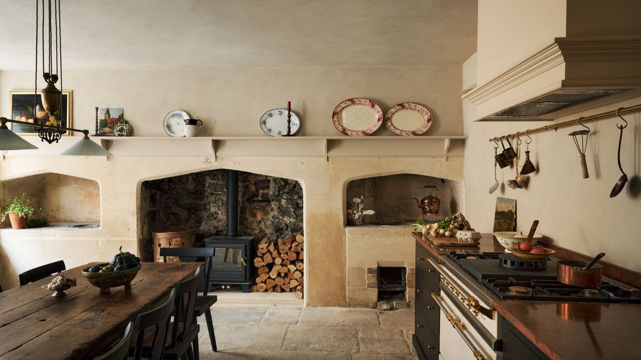 A warm neutral kitchen with a wooden table at the center
