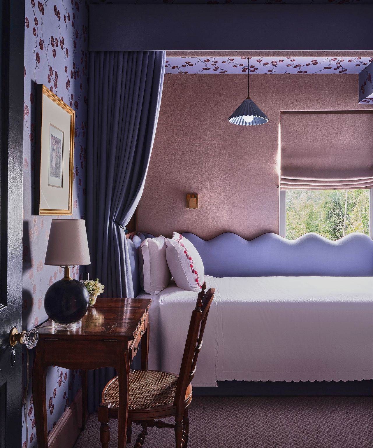 purple bedroom with canopy above the bed and curtain hanging down 